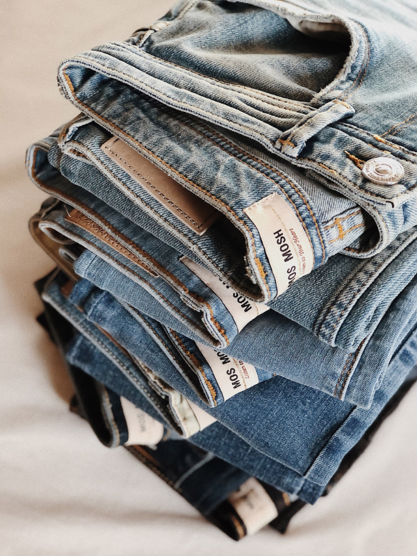 Mehrere Jeans in verschiedenen Tönen von der Marke Mos Mosh sind aufeinander gestapelt.